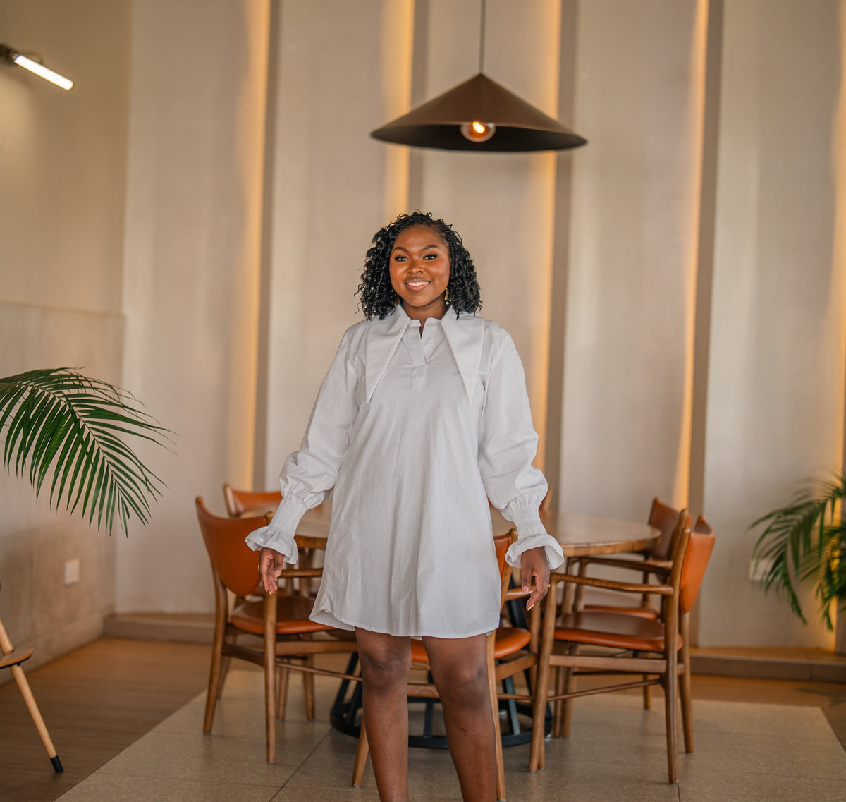 White CHETU shirt dress with a long collar and puff sleeves, full-length front view at a restaurant