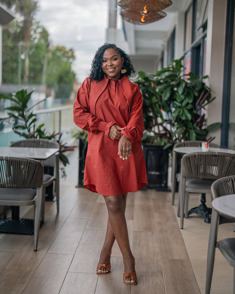 Terracotta CHETU shirt dress with a long collar and puff sleeves, full-length front view at a restaurant