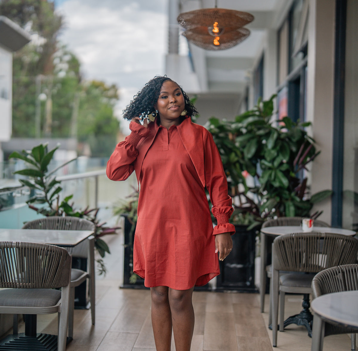 Terracotta CHETU shirt dress with a long collar and puff sleeves, full-length front view at a restaurant